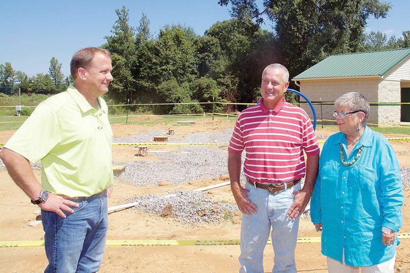 Perryville Mayor John Roland, left, speaks with Tommy Park of Perryville and his sister Sharon Marcum of Little Rock at the site of a splash pad under construction in the city park. The facility will be dedicated in memory of their father, Tom Park, who died in 2009 and was a leader in the community. Money for the Lions Club project, estimated at almost $80,000, is being paid for by the club, the state and the city.