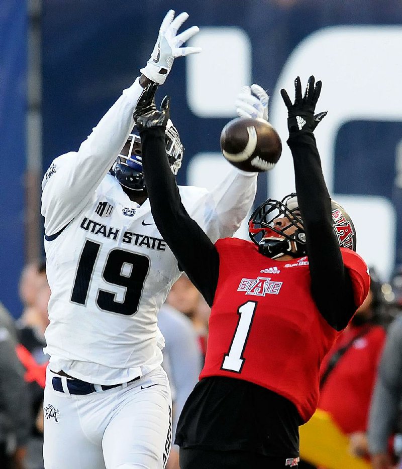 Arkansas State defensive back Blaise Taylor (right) breaks up a pass intended for Utah State’s Ron’Quavion Tarver (19) in the first half of the Aggies 34-20 victory Friday night in Logan, Utah.
