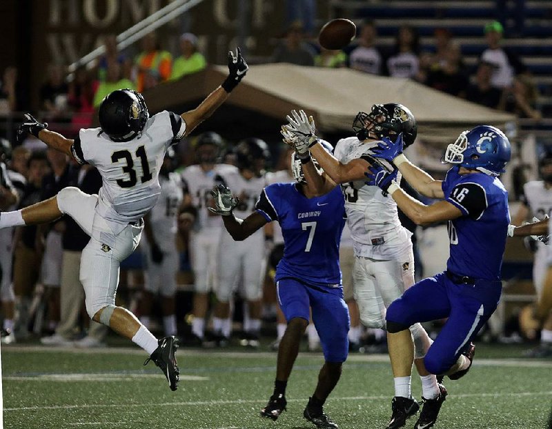 Conway’s Marquis Pleasant (7) and Cole Hoover (16) battle with Noah Mills (31) and another Bentonville defender for a pass in the final seconds of Friday night’s game at Conway.