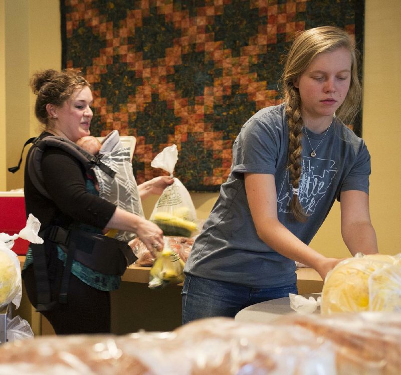 Volunteers Brooke Ware (left) and Kate Walters (right) set out food at Christ Episcopal Church that will be picked up by families participating in the church’s Green Groceries program.