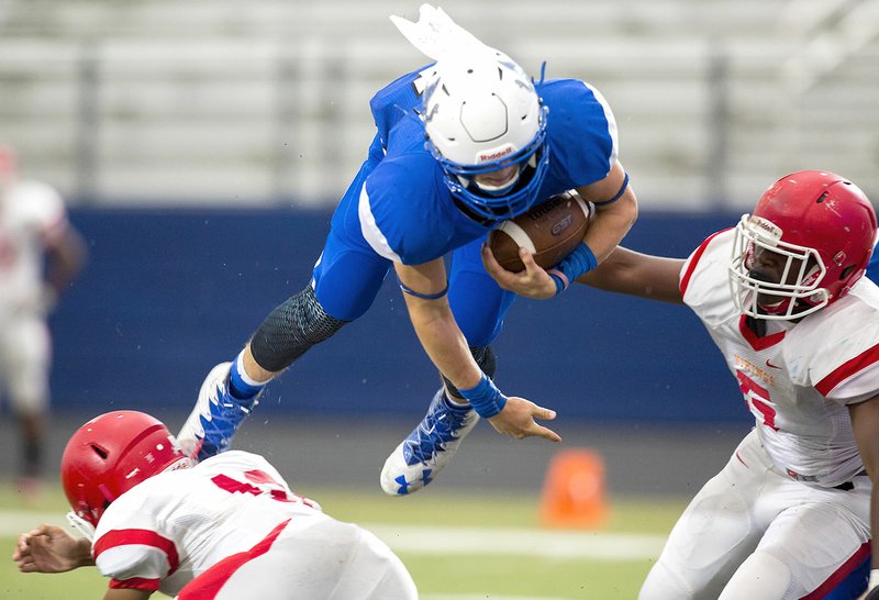 Rogers junior running back Colin McWhorter leaps over Normandy (St. Louis, Mo.) freshman free safety Joshua Washington for a touchdown Friday at Whitey Smith Stadium in Rogers.