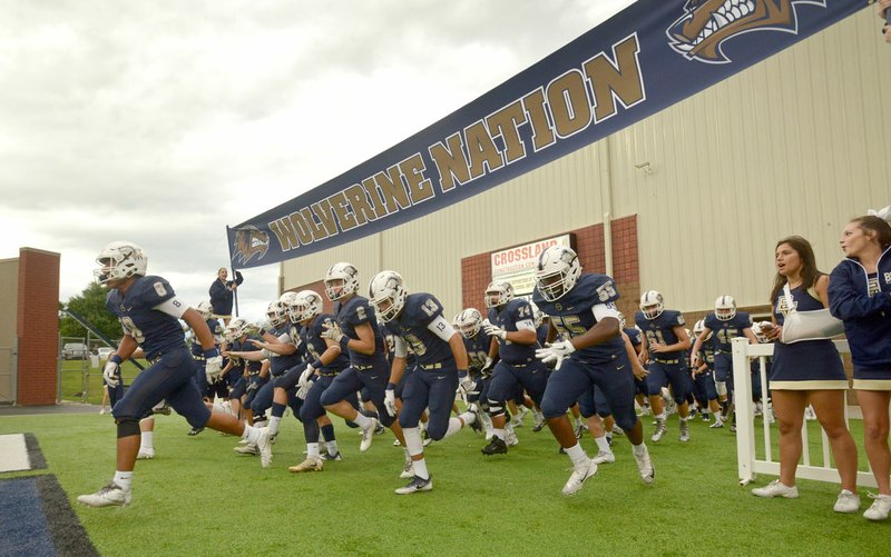 Bentonville West players take the field for their first-ever home game Friday against Muskogee, Okla., at Tiger Stadium in Bentonville.