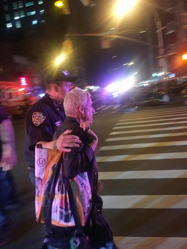 A police officer escorts an injured man away from the scene of a possible explosion on West 23rd Street in New York. Authorities said dozens suffered minor injuries. 