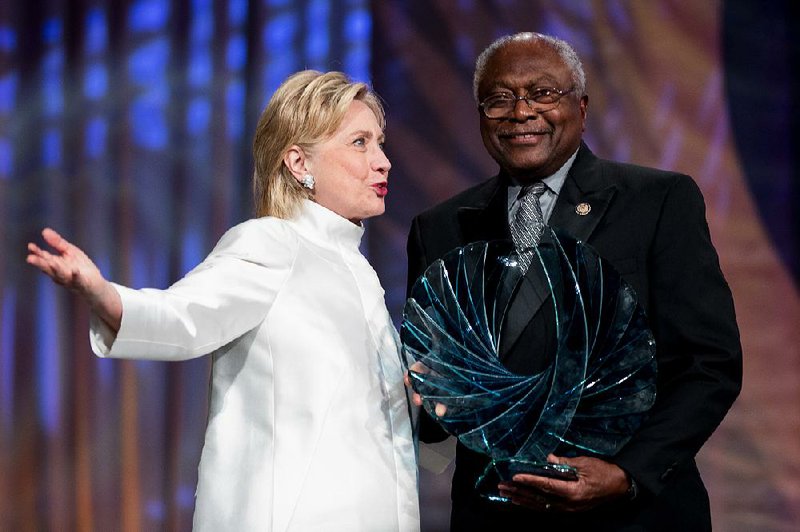 Democratic presidential candidate Hillary Clinton is accompanied by U.S. Rep. James Clyburn, D-S.C., as she receives an award Saturday at the Congressional Black Caucus Foundation’s Phoenix Awards Dinner in Washington.