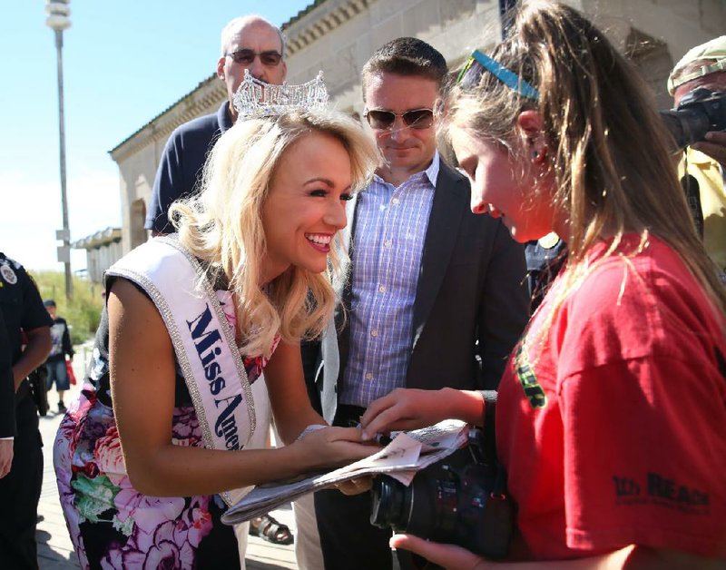 Miss America Savvy Shields, a Fayetteville native, autographs the front page of The Press of Atlantic City on Monday for birthday girl Reagan Dennie, 11, of Little Rock. 