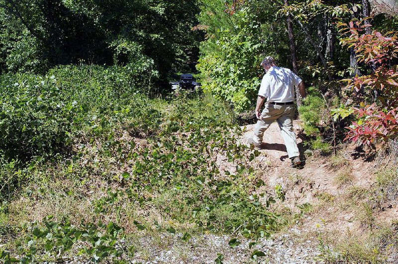 Historical preservationist Marvin Harper of Coker Creek, Tenn., steps Thursday over damage to a section of the Trail of Tears in the Appalachian Mountains.