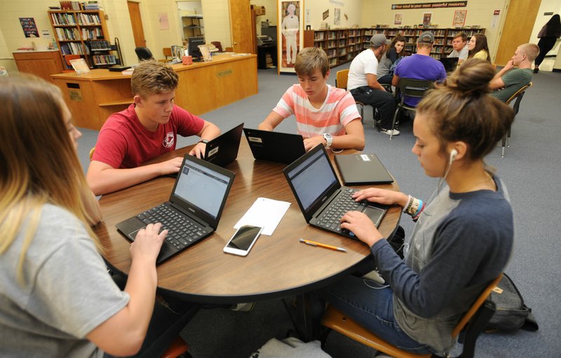 Elizabeth Farris (from left), 16; Mason Ramey, 15; Austin Hayes, 15; and Kendall Hays, 15; all sophomores at West Fork High School, work on laptops Wednesday in the library at West Fork High School. The school has created the Personalized Learning Academy which allows students to learn at their own pace with teachers and mentors to offer instruction and assistance as it is needed.