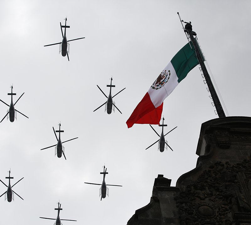 The Associated Press Military helicopters fly past the Mexican flag atop the National Palace Friday during the annual Independence Day military parade in Mexico City's main square, known as the Zocalo. Mexico is marking the 206th anniversary of its independence from Spain.