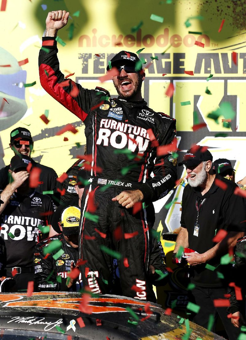 Martin Truex Jr. guaranteed himself a spot in the second round of the Chase for the NASCAR Sprint Cup title after holding off Joey Logano to win the Teenage Mutant Ninja Turtles 400 on Sunday.