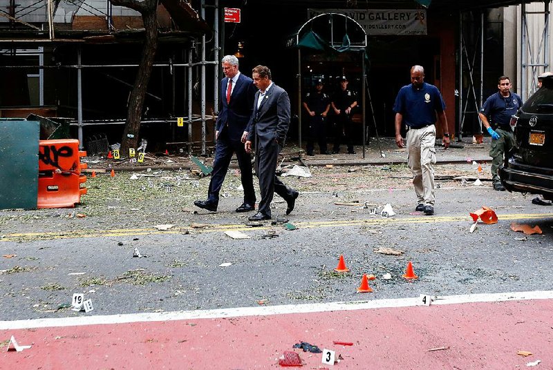 New York Mayor Bill de Blasio (left) and New York Gov. Andrew Cuomo on Sunday tour the site of an explosion in the Chelsea neighborhood of New York.