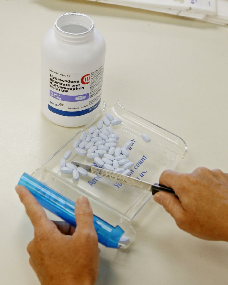 A pharmacy technician shows hydrocodone-acetaminophen tablets, also known as Vicodin, at the Oklahoma Hospital Discount Pharmacy in Edmond, Okla., in this Aug. 5, 2010, fi le photo.