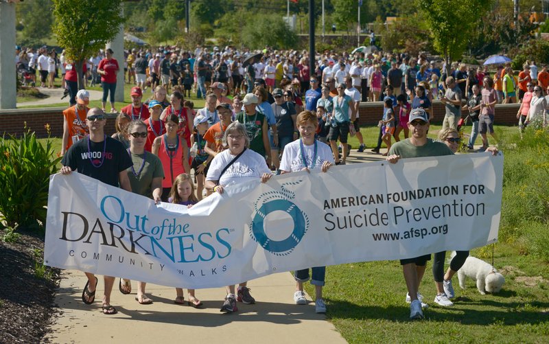 Walkers with the Colin’s Clan group lead on Sunday during the 3rd annual Northwest Arkansas Out of the Darkness Community Walk at Orchards Park in Bentonville.