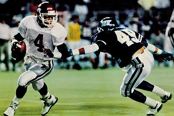 Arkansas quarterback Quinn Grovey is pursued by TCU defender Edward Galariz during a game Saturday, Oct. 7, 1989, in Fort Worth, Texas. The Razorbacks won 41-19.