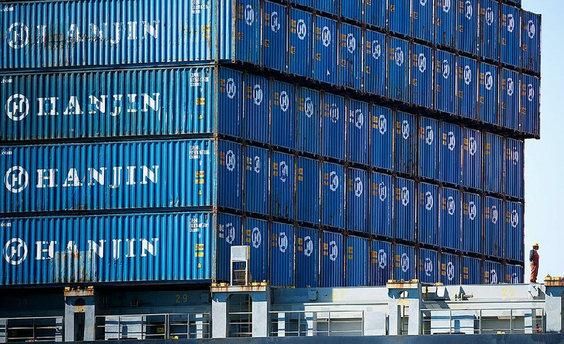 A worker stands near stacked containers on the Hanjin Gdynia cargo ship at the Port of Long Beach in California on Thursday. A Korean court on Monday ordered Hanjin to return all its chartered vessels to cut costs as the shipping company reorganizes.