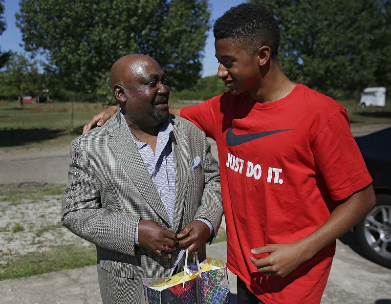 Dwight Beal, 14, hugs the Rev. Joey Crutcher whose son Terence Crutcher was shot and killed by Tulsa police on Friday night.