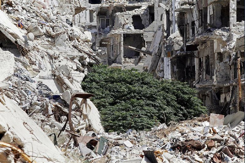 Damaged buildings and rubble line a street Monday in the Old City of Homs, Syria.