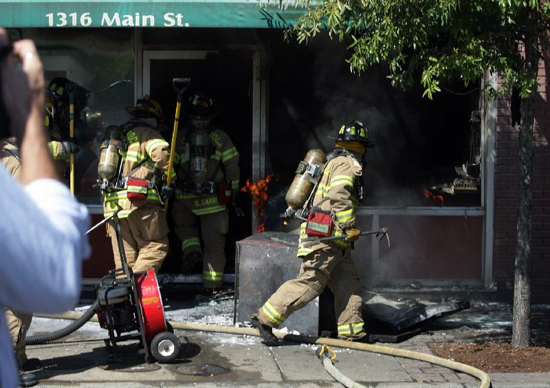 Firefighters battle a blaze at Midtown Billiards on Monday. No one was injured in the fi re and most of the damage was confi ned to the kitchen area, according to fi refi ghters. More photos are available at arkansasonline.com/galleries.