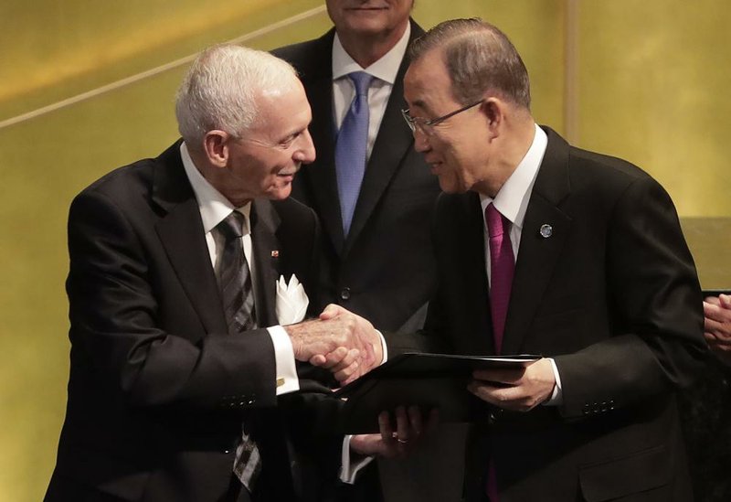 United Nations Secretary-General Ban Ki-moon (right) greets William Lacy Swing, director general of the International Organization for Migration, after signing documents during the opening of a summit to address large movements of refugees and migrants Monday at U.N. headquarters.