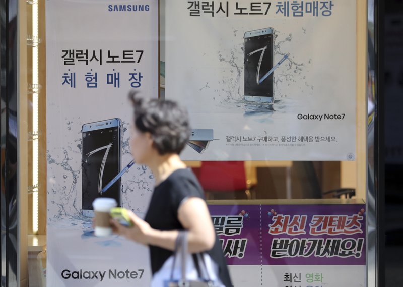 A woman walks by an advertisement of the Samsung Electronics Galaxy Note 7 smartphone in Seoul, South Korea, Monday, Sept. 19, 2016. Samsung said Monday it is investigating reports that two Galaxy Note 7 smartphones caught fire in China, where the company previously said all phones for sale were safe and didn't need to be included in a global recall. 