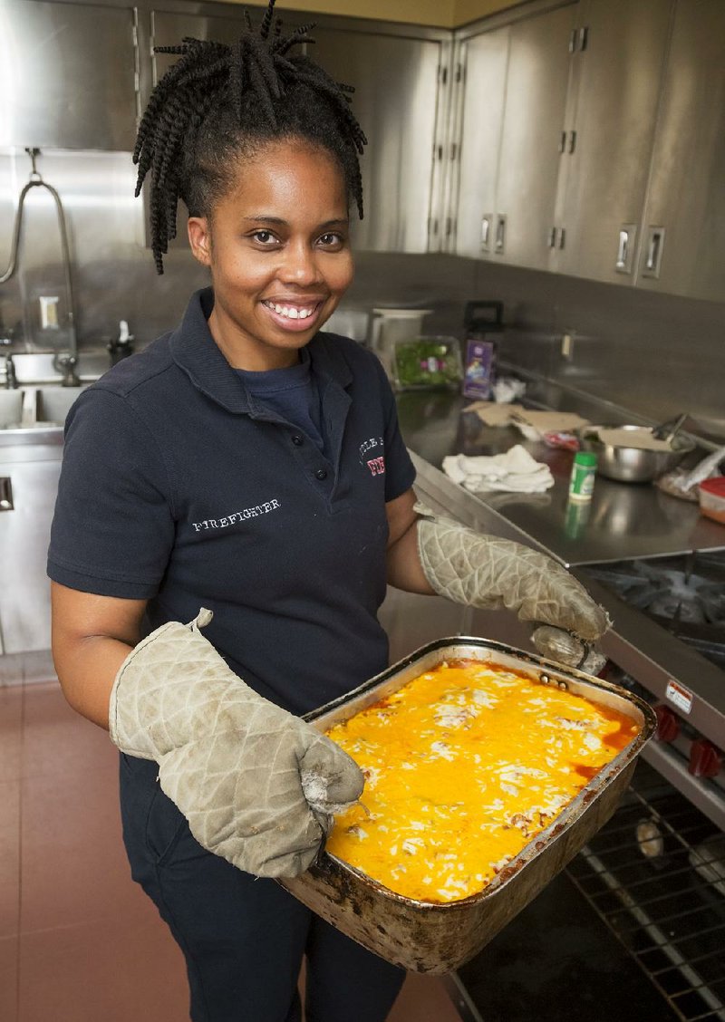 Little Rock firefighter Ashley Coleman pulls her Ultimate Cheesy Lasagna out of the oven at Station 2. The dish is a favorite among her fellow firefighters. 