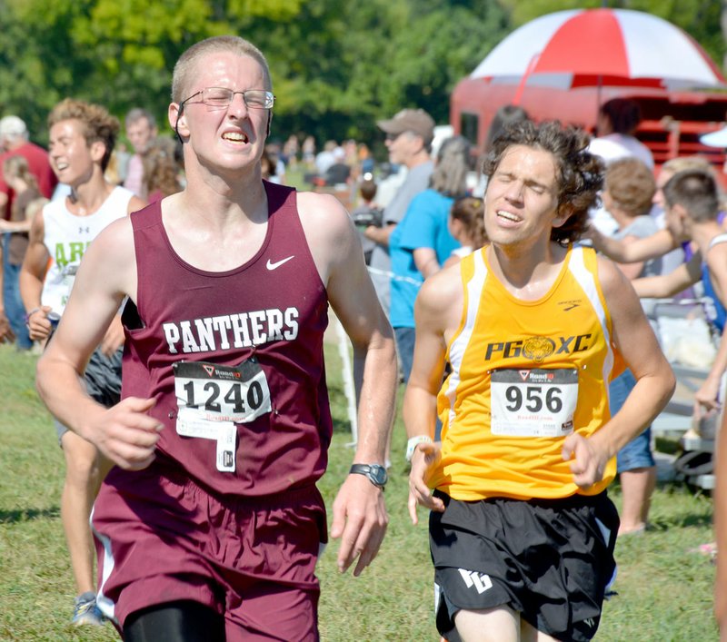 Graham Thomas/Herald-Leader Siloam Springs&#8217; Daniel Norwood runs past Prairie Grove&#8217;s Timothy Frerking near the finish line Saturday at the Panther Cross Country Classic.