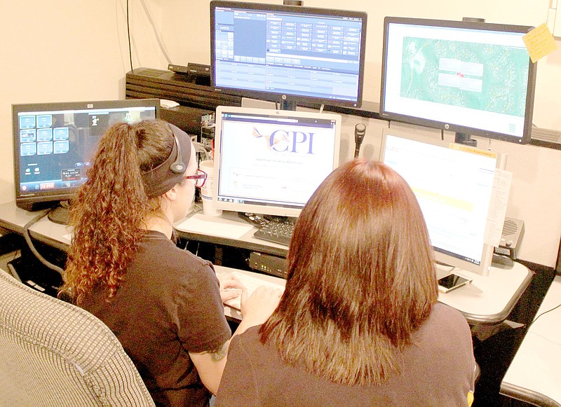 Keith Bryant/The Weekly Vista Dispatch trainee Diamond Neill, left, works with dispatcher Alisha Larson in the Bella Vista Police Department&#8217;s dispatch office.