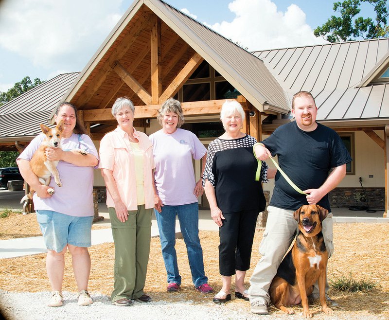 The Stone County Humane Society recently opened its brand-new animal shelter. Standing in front of the new building are, from left, staff member Rachael Gosser, holding Charlotte, Humane Society vice president Bonnie Dumas, secretary Deanna Binson, president Tina Holmlund and volunteer Gresham McMillon, with Daisy. 