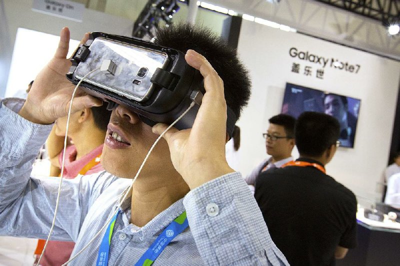 A visitor tries a Samsung Gear Virtual Reality headset at a Samsung display booth during an electronics expo in Beijing on Wednesday. Samsung users in China are complaining that the company is doing little to reassure them that their new Note 7 smartphones are safe. 