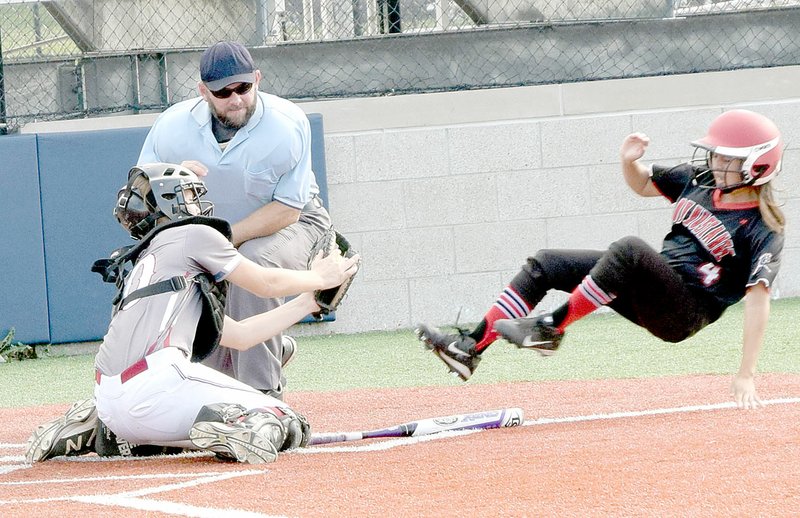 PHOTO BY RICK PECK McDonald County pinch runner Myrian Martinez goes airborne in a failed attempt to beat a tag by Joplin catcher Mikayla Kuehnal during the Lady Mustangs 11-2 win on Sept.