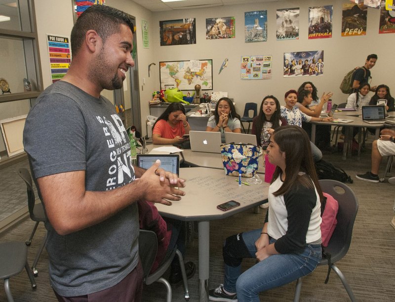 Martin Resendiz, a Spanish teacher at New Technology High School, is greeted by his students Thursday in Rogers. Resendiz is one of 20 teachers nationwide chosen as one of Wal-Mart’s “Commander in Teach(ers).”