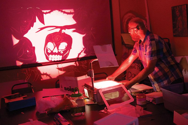 Adam Frank, University of Central Arkansas Honors College professor, shows one of the shadow puppets — The Mexican Pumpkin representing the Day of the Dead — that will be featured in The Halloween Tree. UCA student Adrienne Thompson is the lead artist of a team that has created more than 100 shadow puppets for the upcoming production.