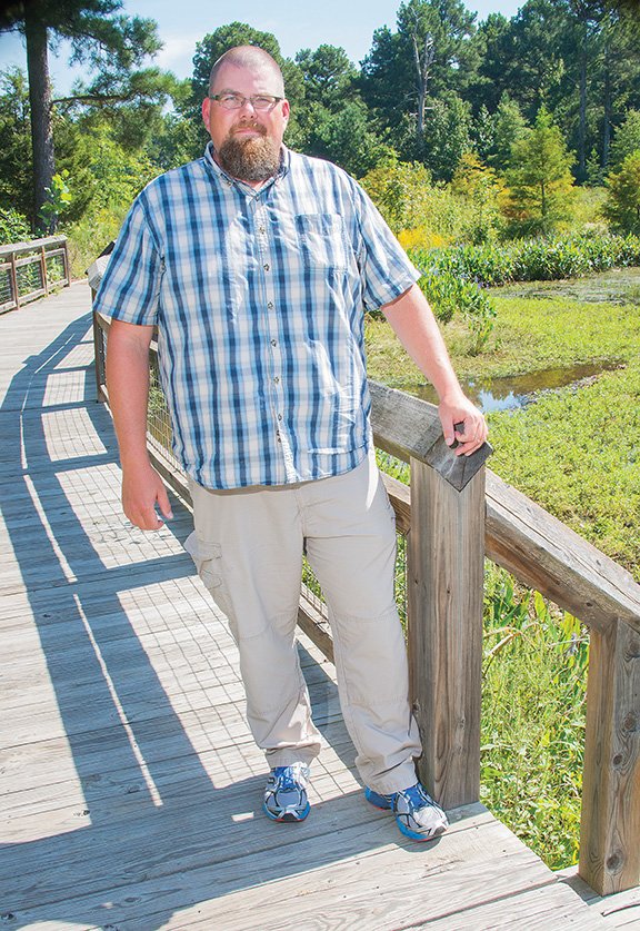 Clint Turnage of Saltillo, wildlife disease biologist for the U.S. Department of Agriculture, stands on the bridge in the Hendrix Creek Nature Preserve in Conway. “I’ve loved the outdoors all my life,” he said. Turnage, 41, was named 2016 wildlife disease biologist of the year by the USDA in June. His job has taken him all over Arkansas, as well as Iowa, Alaska and New Mexico.
