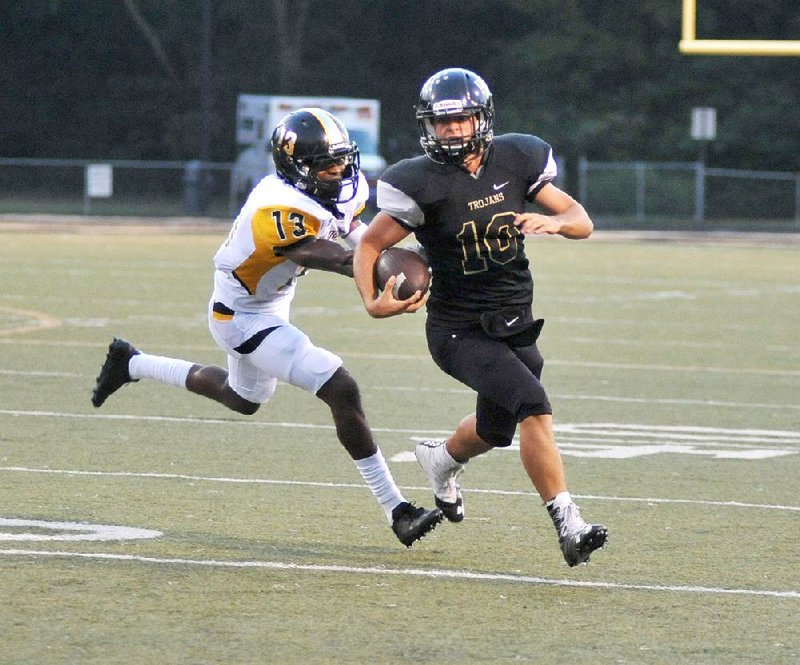 Watson Chapel defender Alex Herrien (left) chases down Hot Springs quarterback Korey Wasson in Friday night’s
5A-South opener. Wasson fi nished with 52 yards rushing, but the Wildcats pulled away for a 42-14 victory.