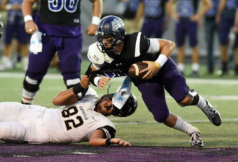 Bentonville’s Collin Honeycutt (82) loses his helmet as he pulls down Fayetteville quarterback Taylor Powell during Friday night’s game at Fayetteville.