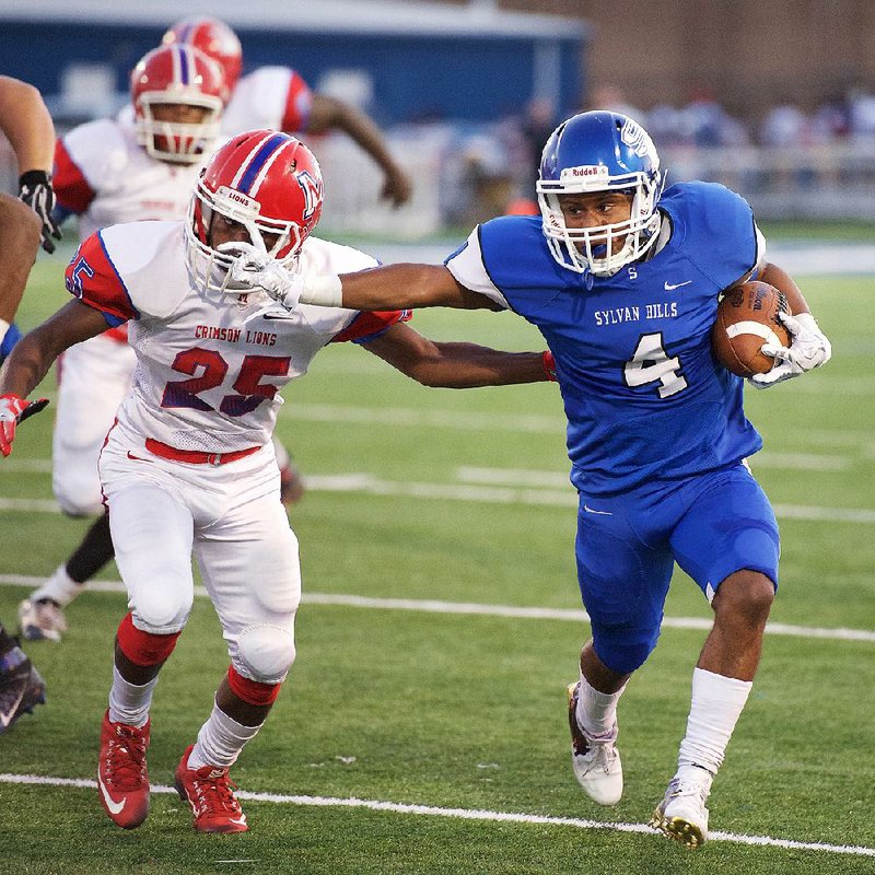 Sylvan Hills running back Jamar Porter (right) stiff arms Little Rock McClellan defensive back Tyrse Lair
during the first half of Friday’s game. The Bears had 419 yards of offense to beat the Lions 41-20.