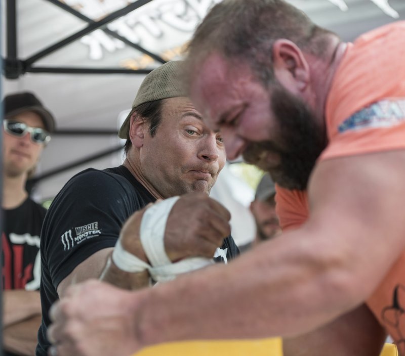 Devon Larratt (left) arm wrestles friend Michael Todd on Friday at a World Armwrestling League demonstration booth at the Arvest Ballpark parking lot in Springdale. Larratt is the current league champion. A group from the league was at the ballpark as part of Bikes, Blues &amp; BBQ. The Arvest location includes several booths, trick riding demonstrations and food.