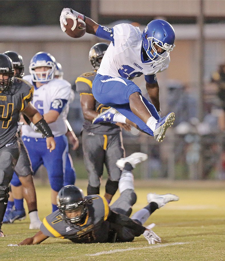 Michael Orrell/News-Times Parkers Chapel's Dezmon Jackson leaps over a Hampton defender on his way for a touchdown in the first half on Friday night in Hampton. Hampton defeated the Trojans 50-28.