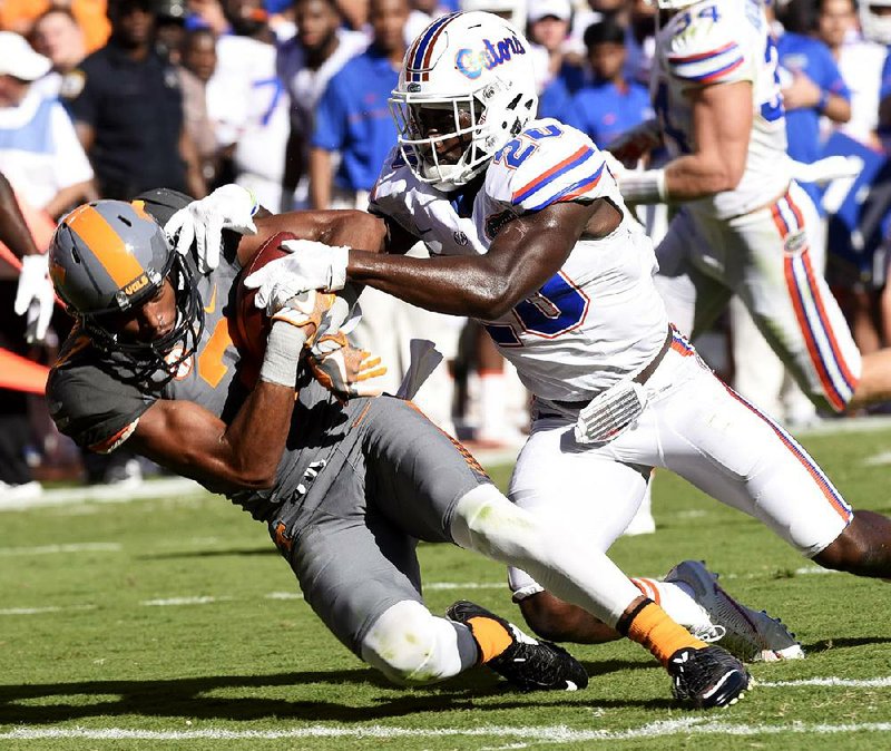 Tennessee wide receiver Josh Malone (left) holds on to the ball while being hit by Florida safety Marcus Maye in the second half. The Volunteers ended their 11-game losing skid to the Gators with a 38-28 come-from-behind victory. It was Tennessee’s 10th victory in a row dating back to last season.
