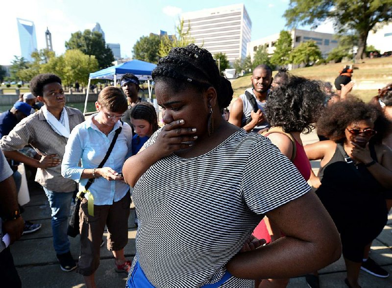 Protesters in a park in Charlotte, N.C., listen Saturday to city Police Chief Kerr Putney’s announcement that he would release video footage of last week’s fatal police shooting.