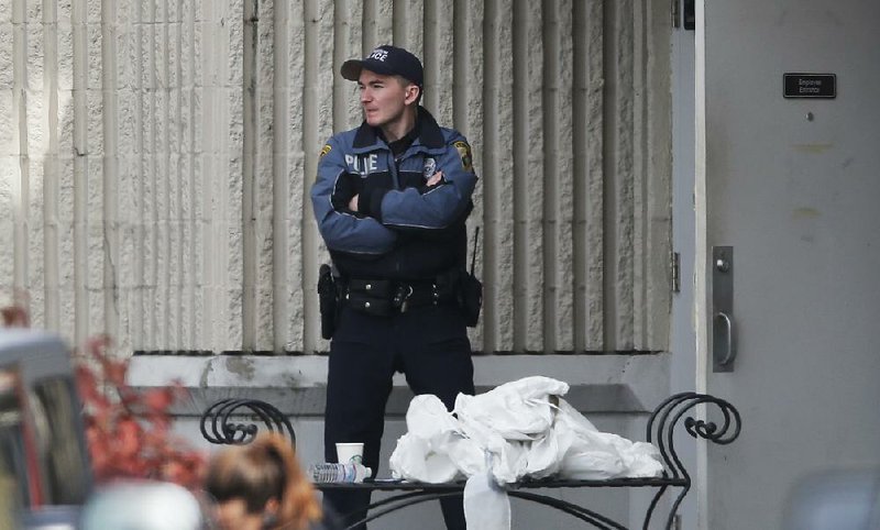 A police officer guards a side entrance to the Macy’s department store Saturday at the Cascade Mall in Burlington, Wash., after Friday’s fatal shooting.