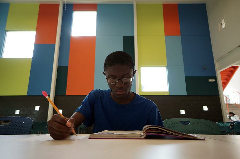 Kleontae Green, 15, a sophomore at Little Rock Central High School, does his homework at the Our House shelter Friday. Green said he doesn’t tell everyone that he lives in a shelter, and sometimes his teachers don’t realize he’s homeless.