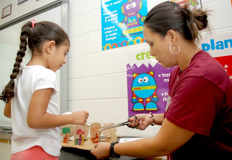 Janelle Jessen/Siloam Sunday Eumia Fullerton, teacher of the new science, technology, engineering, art and math class at Northside Elementary School, helped a student add a cardboard dot to the sculpture the class was making on Friday morning.