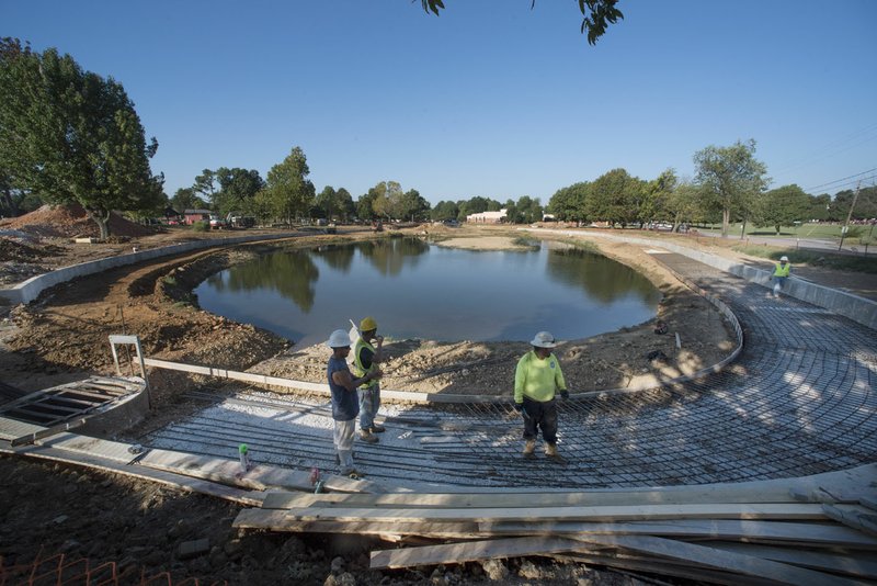 A construction crew works on laying rebar Friday as they work to create walls and improve Murphy Park’s pond in Springdale.