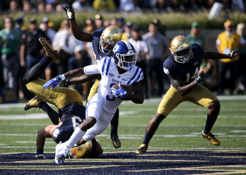 Duke wide receiver T.J. Rahming (center) runs past three Notre Dame defenders after catching a pass Saturday during the Blue Devils’ 38-35 victory over Notre Dame in South Bend, Ind.
