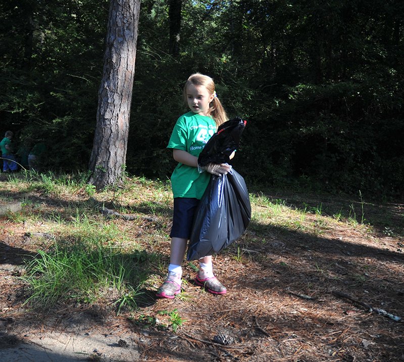 The Sentinel-Record/Mara Kuhn Skyelah Rudd, 7, of Bismarck, along with members of the Creative Clovers 4-H Homeschool of Hot Springs, picks up trash Saturday at Carpenter Dam Park during the annual Trash Bash. A part of Keep Arkansas Beautiful and the Great Arkansas Cleanup, up to 700 people have participated in the Trash Bash in recent years, including Girl Scouts, Boy Scouts and Cub Scouts, 4-H Clubs, ROTC units, organizations and individuals.