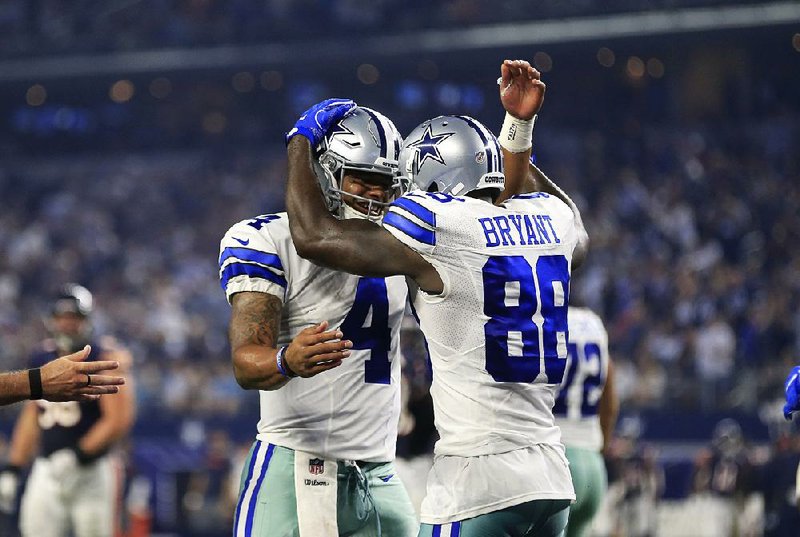 Dallas Cowboys quarterback Dak Prescott (left) celebrates with wide receiver Dez Bryant after they connected on 17-yard touchdown pass in the fourth quarter of the Cowboys’ 31-17 victory over the Chicago Bears on Sunday night in Arlington, Texas.