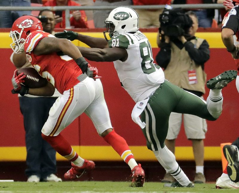 Kansas City Chiefs linebacker Derrick Johnson (left) scores a touchdown against New York Jets wide receiver Quincy Enunwa (81) after intercepting a pass intended for Jets running back Matt Fort during the second half of Sunday’s game in Kansas City, Mo. The Chiefs’ defense intercepted six passes during the game and scored two touchdowns off turnovers.