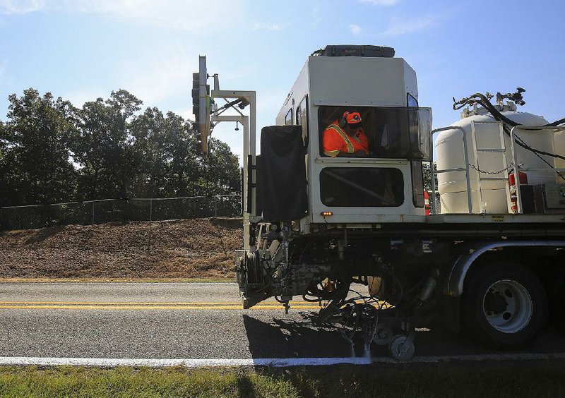 State machinery maintains road markings Thursday on a roadway near Houston, Ark.