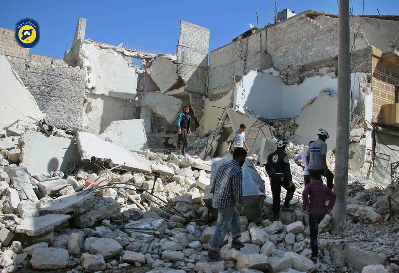 Members of the Syrian Civil Defense group and residents inspect damaged buildings Sunday after airstrikes hit the Bustan al-Qasr neighborhood in Aleppo, Syria.
