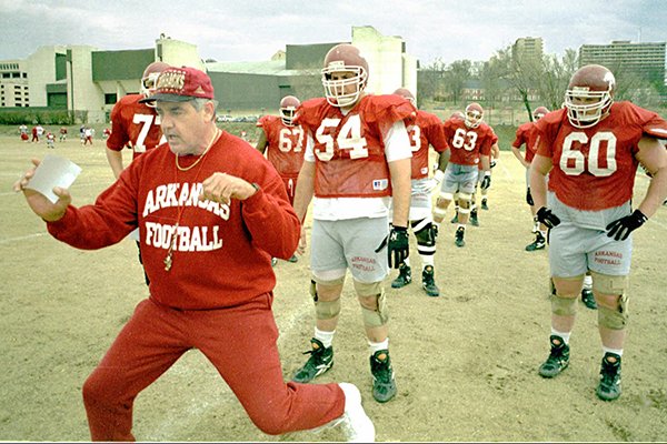 Arkansas offensive line coach Mike Bender demonstrates blocking techniques to the guards and centers during practice on Monday, April 8, 1996, at Razorback Stadium in Fayetteville